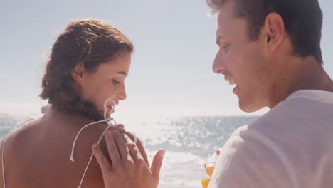 man putting sunscreen to his girlfriend