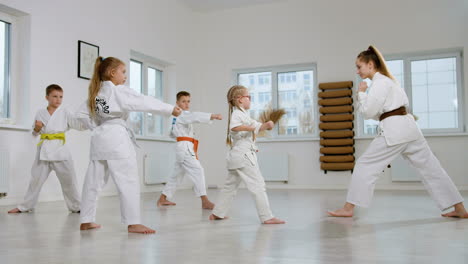 niños en kimono blanco en la clase de artes marciales