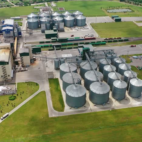 large granary in field. a new built-in industrial grain elevator among nature. silver containers for storing agricultural products. aerial view.