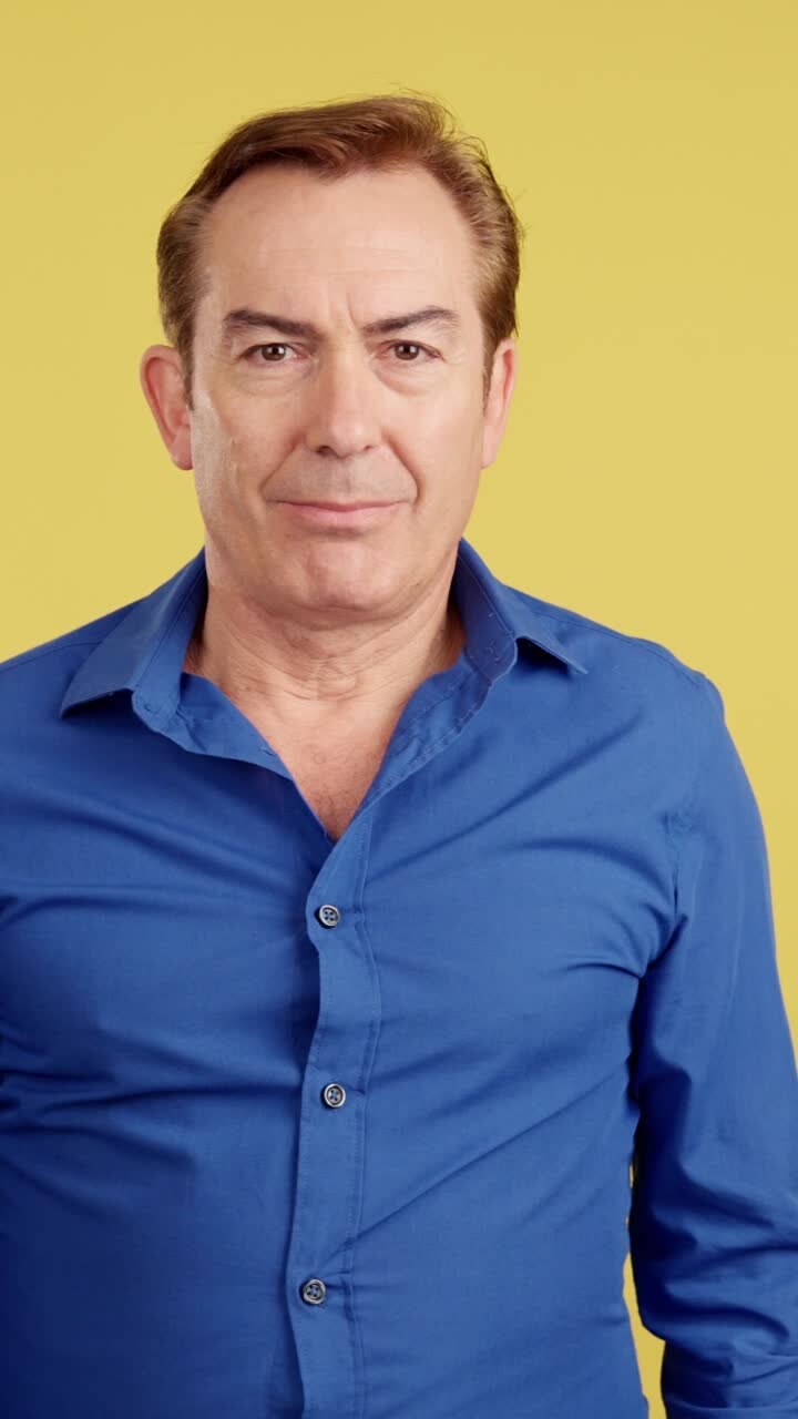 Portrait of a Man with Crossed Arms against a Yellow Background