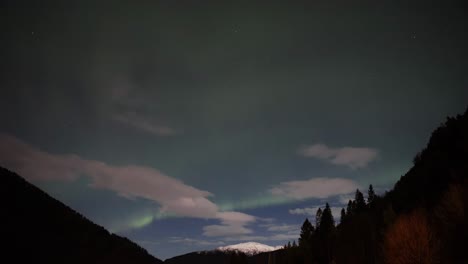 Realtime-Aurora-Borealis-over-western-Norway-night-sky-and-silhouetted-mountains