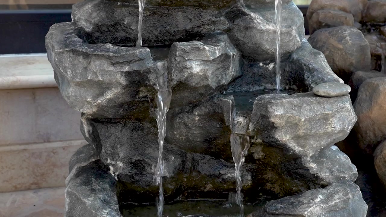 Acqua che scorre da una fontana in pietra - Primo piano