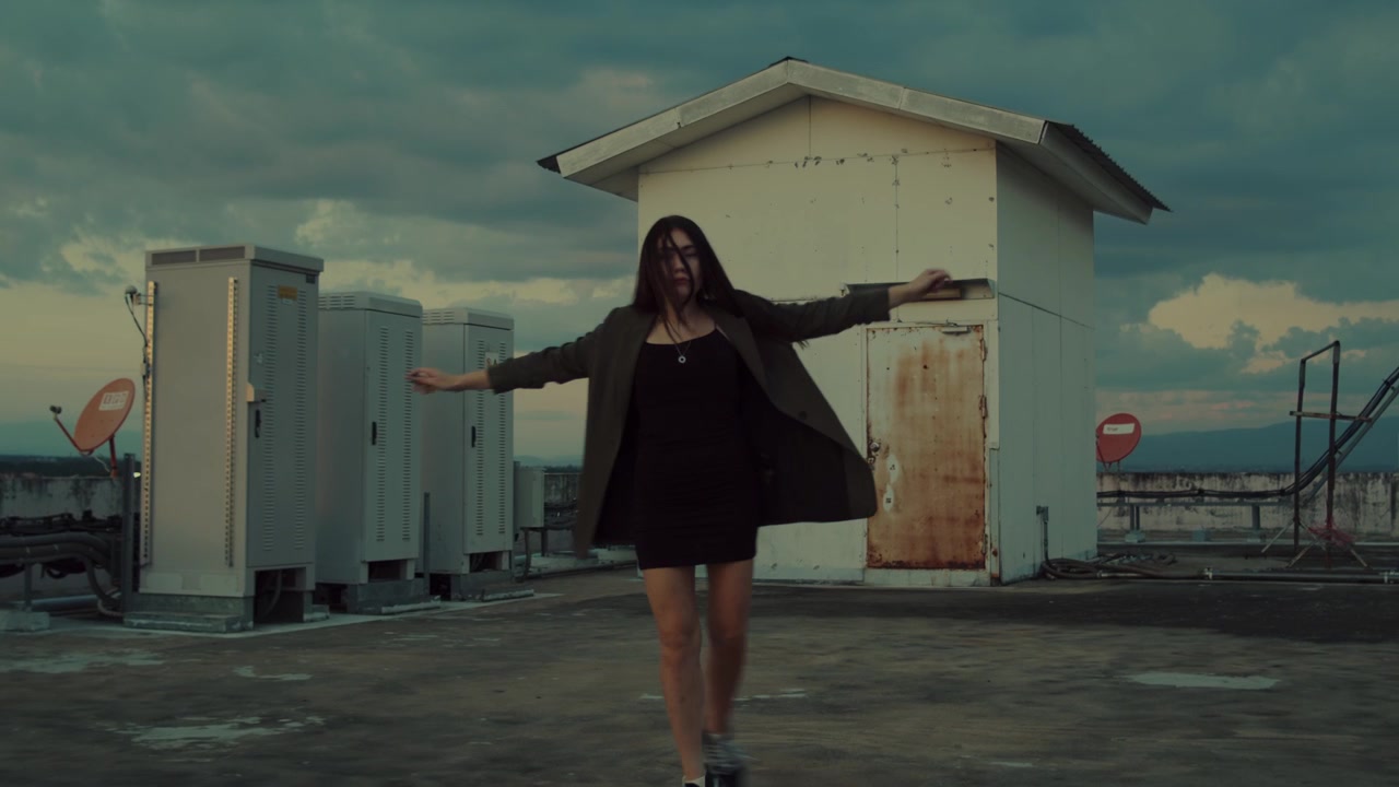 Jovem Mulher Dançando no Terraço ao Pôr do Sol