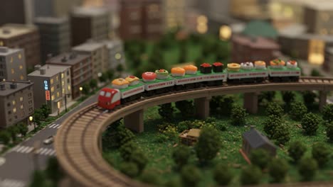 a whimsical miniature train journey through a lush model town, featuring delightful food-themed train cars curving around a scenic landscape