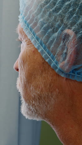 médico pensativo de pie cerca de la ventana
