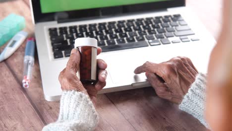 elderly person checking medical information on laptop