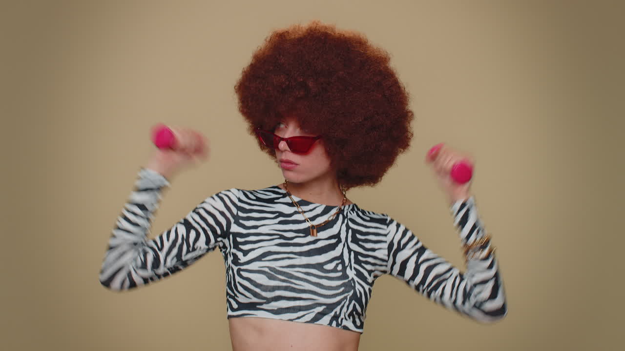 mujer haciendo ejercicio, bombeando los músculos de los brazos levantando pesas rosas, practicando pilates, atención médica