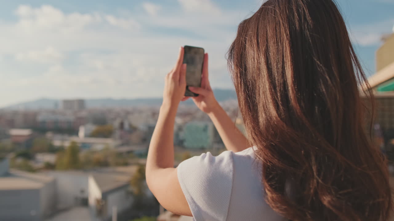 Woman taking photo of city skyline with her smartphone