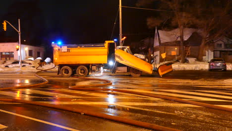 un quitanieves rocía sal en las carreteras mojadas para reducir la nieve y el hielo