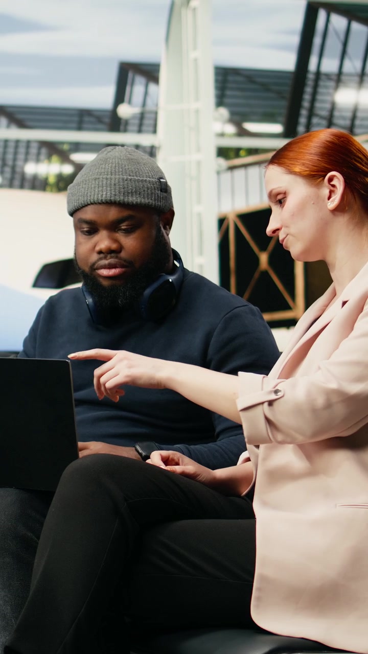 Vertical Video Team of diverse consultants typing on laptop in airport lounge