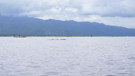 boating across inle lake, myanmar in cloudy conditions