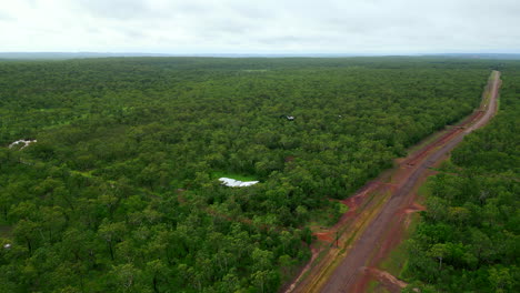 Drone-Aéreo-De-Finca-Rural-En-El-Interior-Con-Casa-En-Un-Pequeño-Claro-De-Bosque-Llano-Territorio-Norte-De-Darwin-Australia