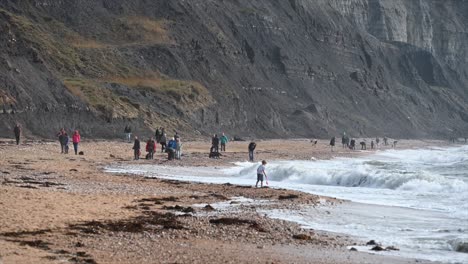 La-Gente-Disfruta-De-Estar-En-Una-Playa-Hecha-De-Guijarros-En-El-Sur-De-Inglaterra,-Dorset