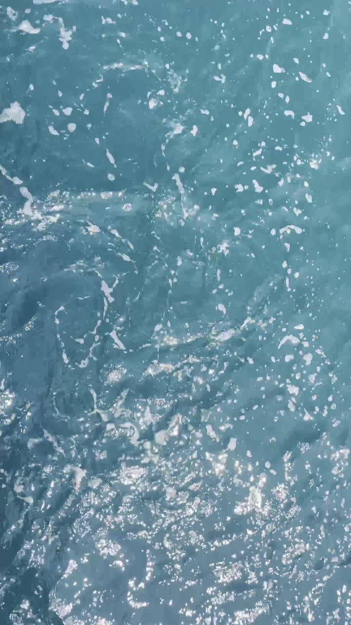 Vertical aerial fly above blue sea salty water texture, fast pattern, natural landscape