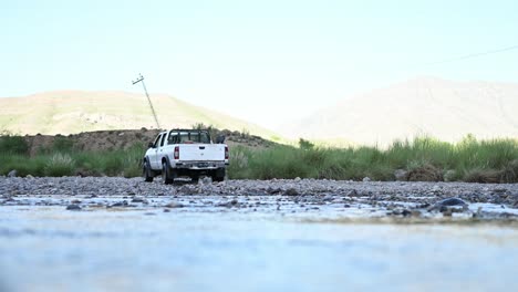 view of parked white truck across flowing river