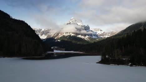 Obersee-Glarus-Näfels-Switzerland-low-flight-over-melting-ice-towards-base-of-lake-mountain