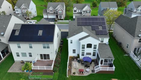 new houses in modern neighborhood with solar panel arrays on shingle rooftops