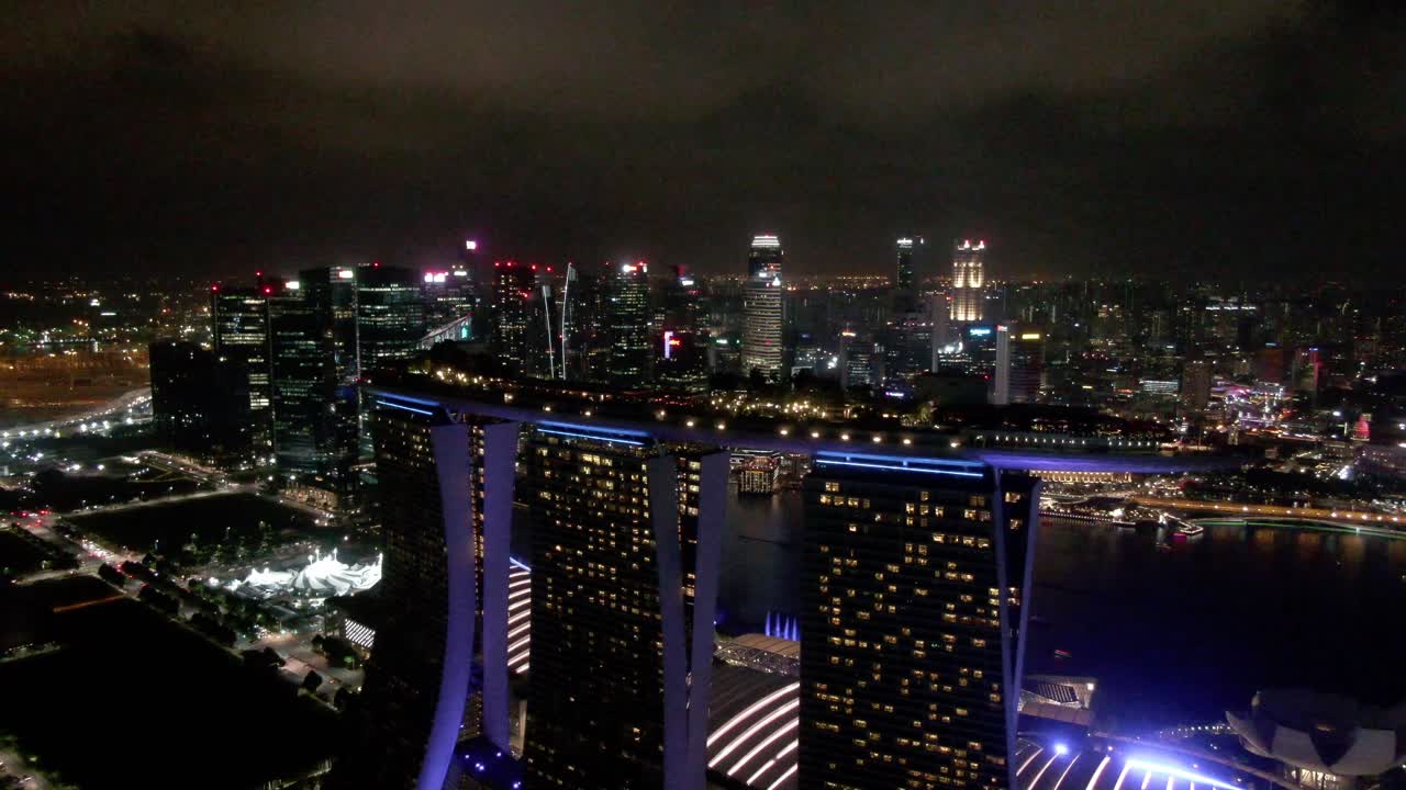 Flying out and around the Marina Bay Sands Hotel at night with the Singapore skyline in the background