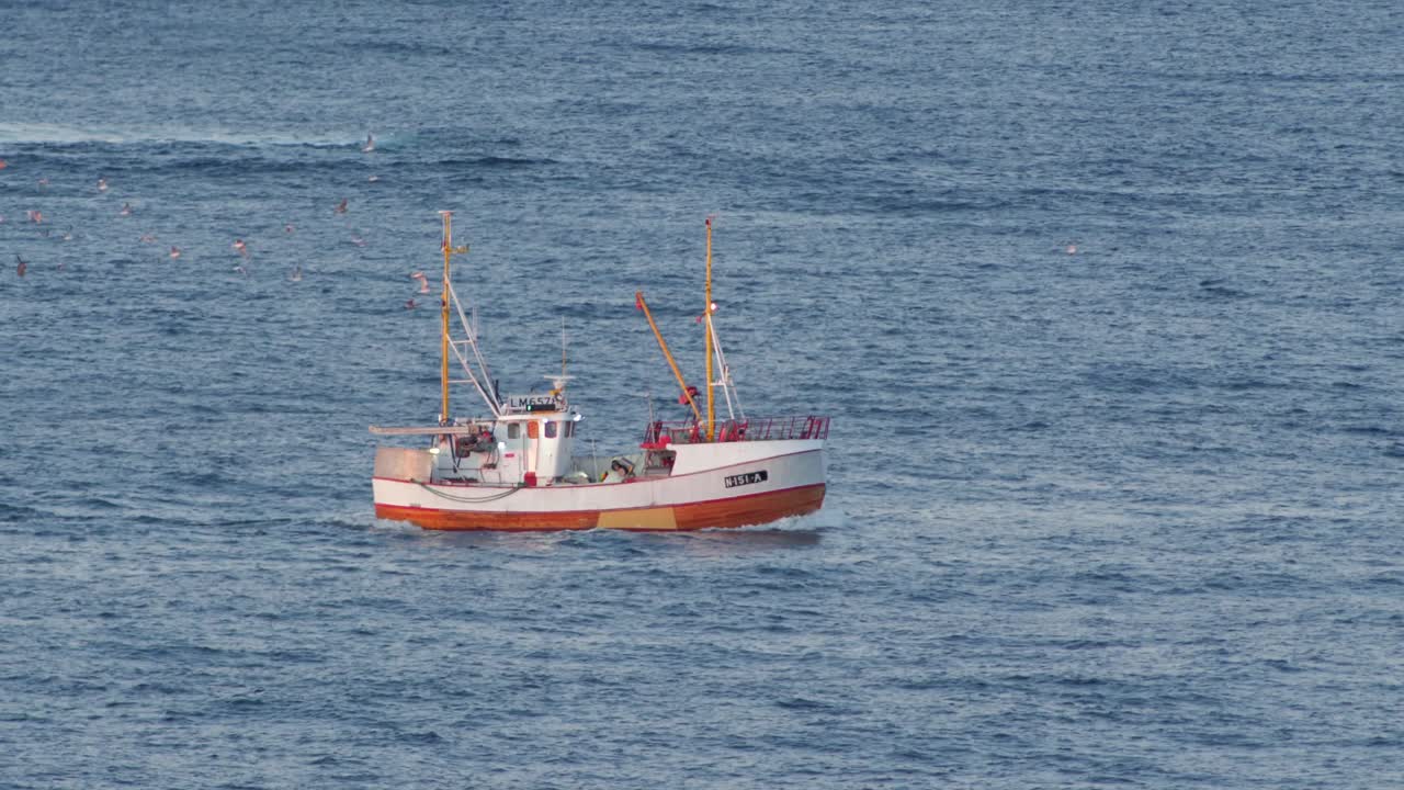 piccola barca da pesca bianca che naviga su un mare aperto della norvegia settentrionale, rallentatore a 60 fps