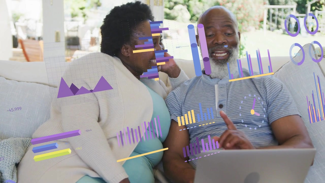 Un couple mûr sur un canapé, l'homme utilisant une tablette tactile pour afficher des graphiques financiers en surimpression, le couple consultant ses fonds.