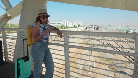 tourist checks her messages while waiting on a bridge