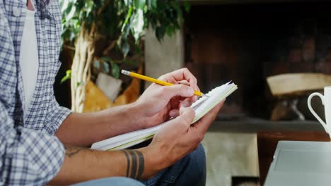 man taking notes at home