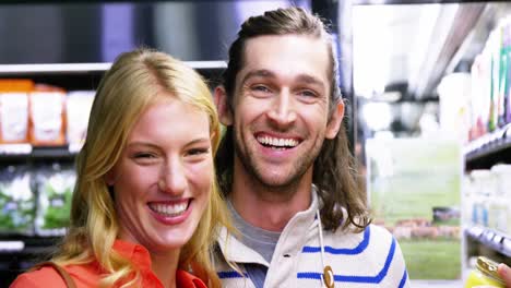 happy couple standing in supermarket