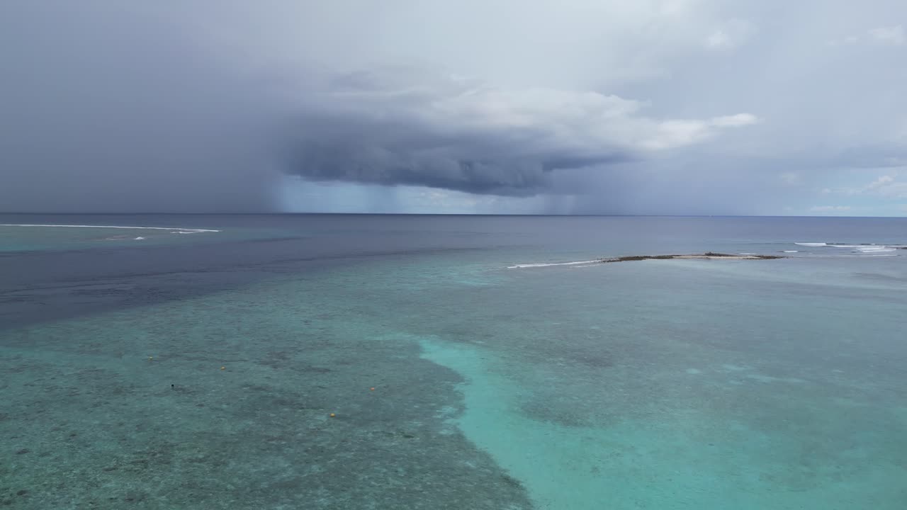 Maldive island , aerial footage coral reef Indian Ocean with tropical storm at distance