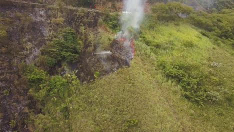 vuelo aéreo hacia un bombero irreconocible apagando un incendio de vegetación