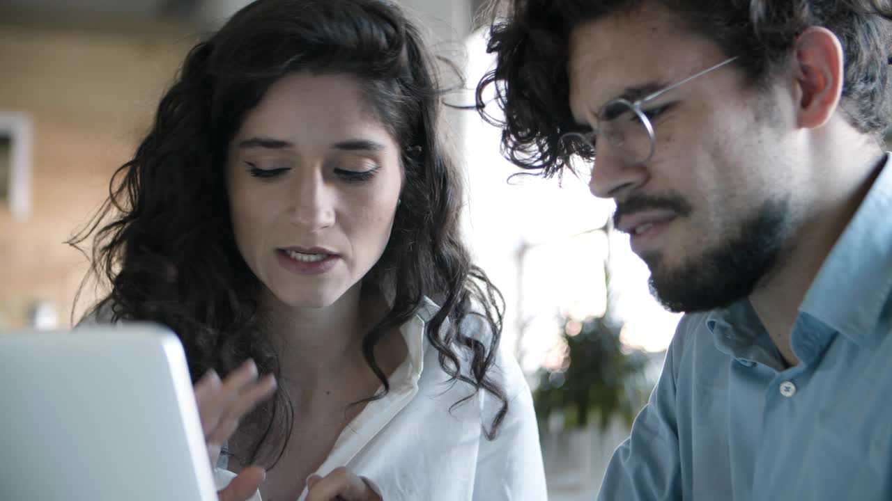 disparo en primer plano de jóvenes colegas sonrientes mirando la computadora portátil