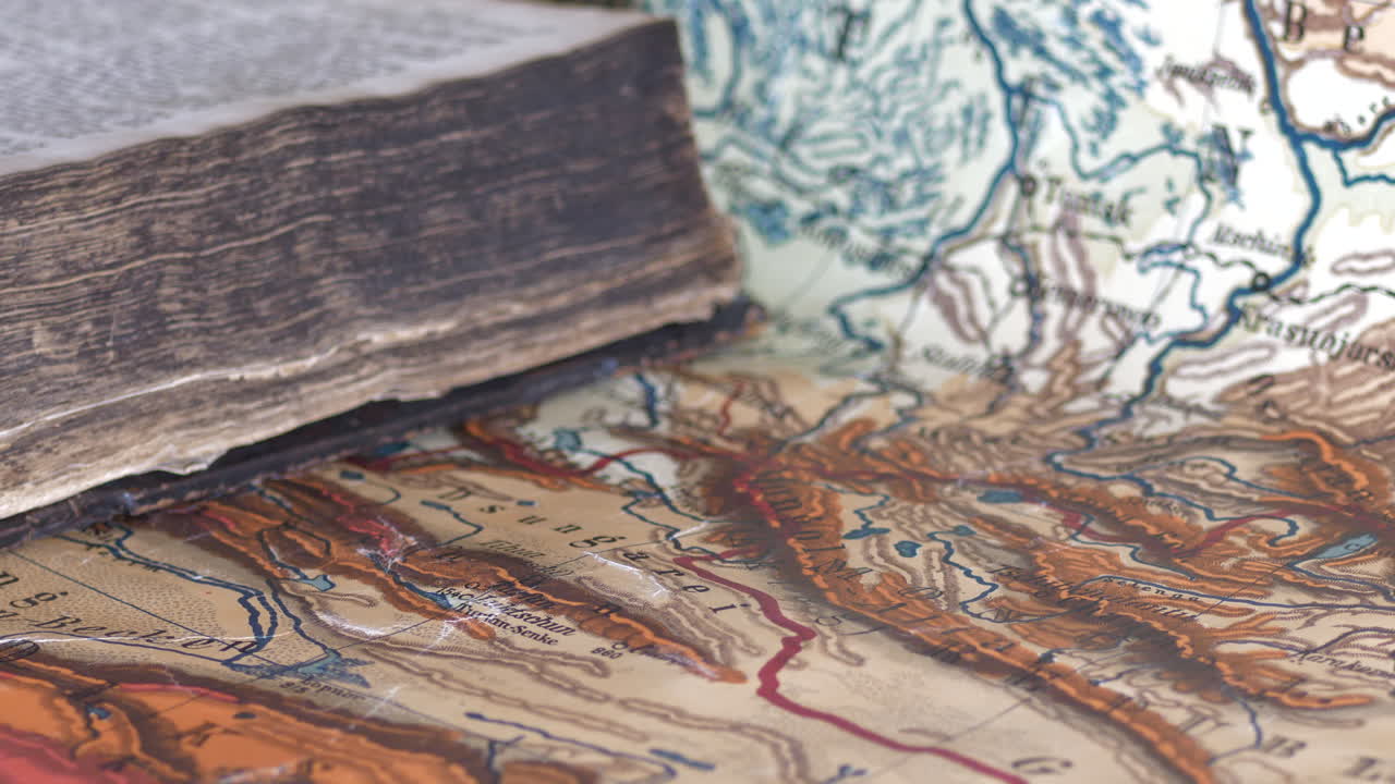 다채로운 지도, 얕은 dof에 누워 착용된 오래 된 책의 근접 팬