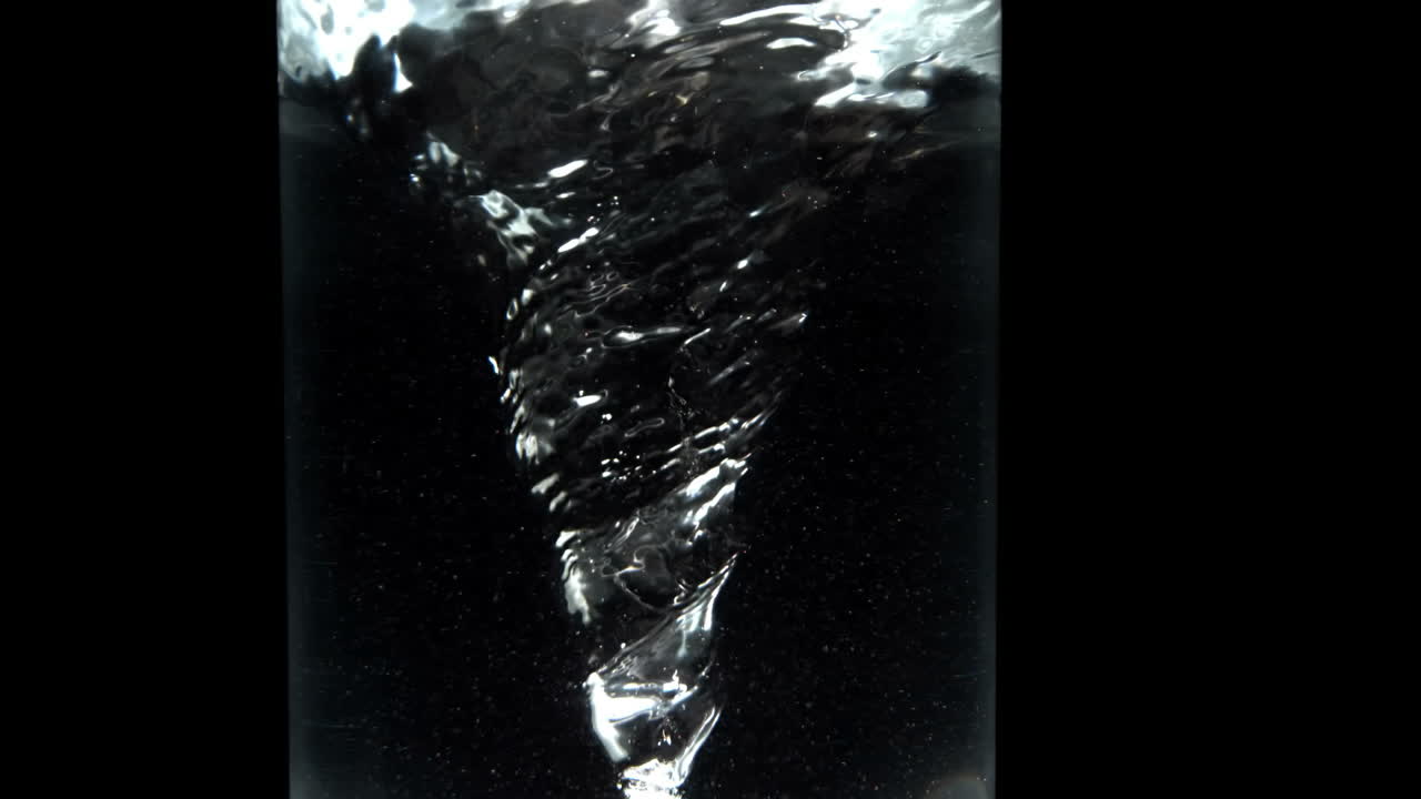 검은색 배경 에 있는 물 한 잔 에 있는 소용돌이