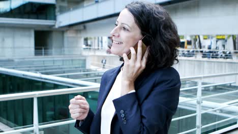 mujer de negocios sonriente hablando por teléfono celular