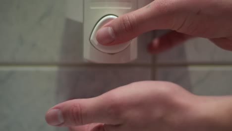 Close up of two hands getting dose of liquid soap out of a soap dispenser.