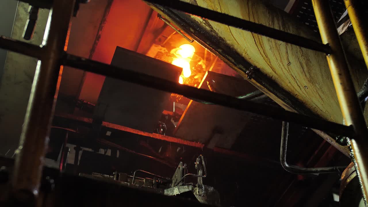 Burning blanks of glass bottles in an industrial stove in Glassworks