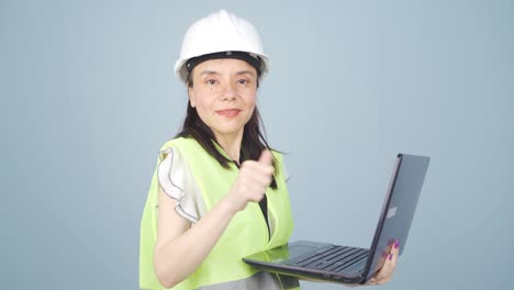 engineer holding laptop laughing at camera.