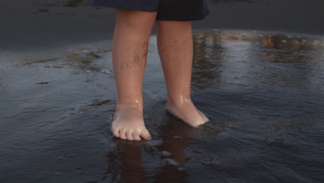 Niño-Pequeño-En-La-Playa-De-Arena-Negra