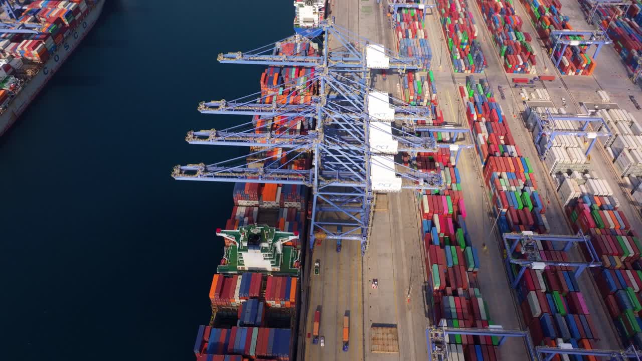 Container per spedizioni allineati sotto le gru al porto industriale di Atene