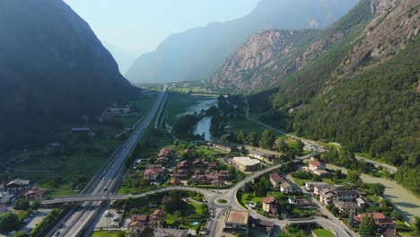 Scenic-aerial-view-of-Aosta-Valley,-Italy-with-mountains,-river,-and-village,-sunny-day