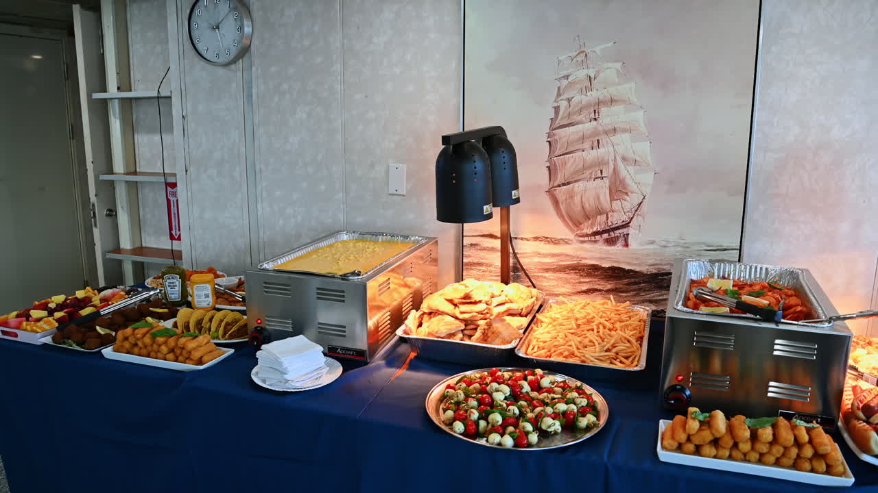 New York, USA, 1 agosto 2025: Tavolo buffet di una nave da crociera con piatti caldi e patatine fritte. Buffet caldo con maccheroni, patatine fritte, dolci e gamberetti serviti sotto luci calde su una nave da crociera