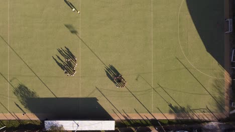 two hockey teams prepare for the game on a beautiful green field in buenos aires