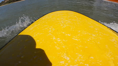 Primer-Plano-De-Una-Tabla-De-Surf-Amarilla-A-Lo-Largo-De-La-Orilla-Del-Mar-En-Mui-Ne,-Vietnam-En-Un-Día-Soleado