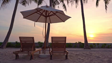 empty beach beds and parasol for two on sunset sunlight at tropical destination