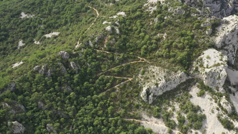 trail on a mountain with mediterranean scrubland aerial drone shot. sunny day