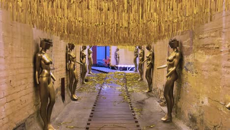 golden walkway with mannequins on both sides of the corridor