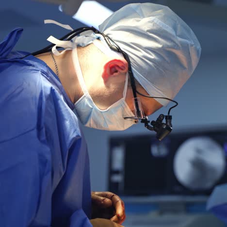professional surgeon during operation. doctor in medical uniform and magnifying glasses performs a surgery with sterile medical instruments. profile view