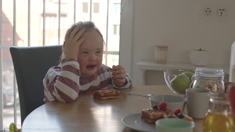 girl with down syndrome eating breakfast