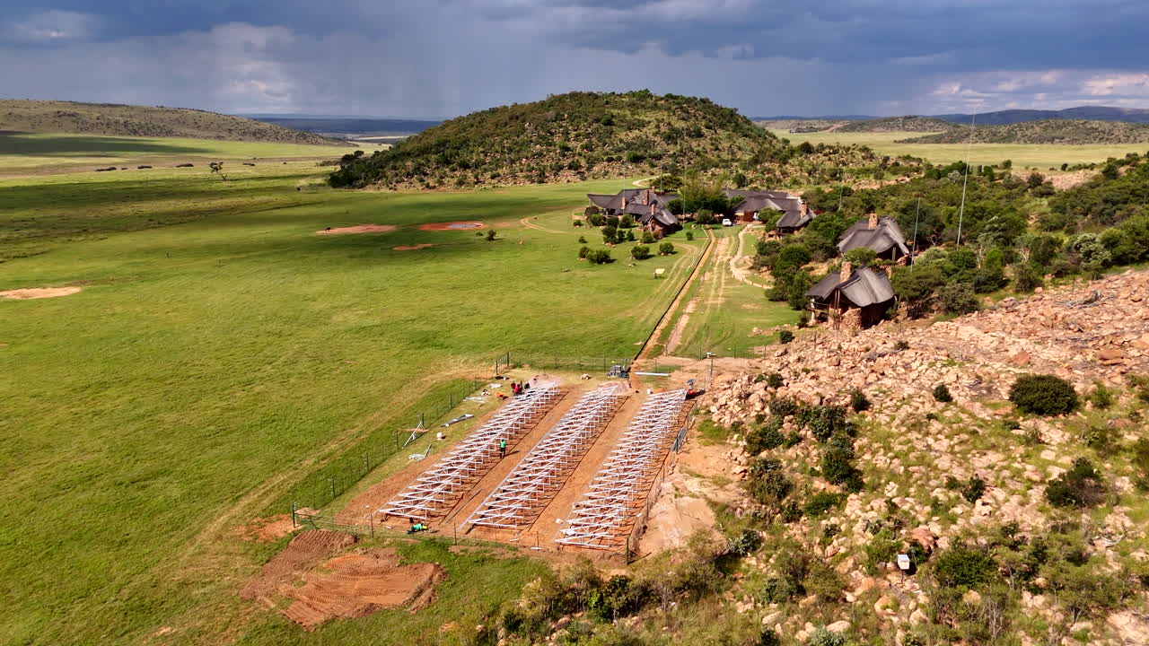 Aerial panning, solar site at luxury safari lodge and dramatic African sky