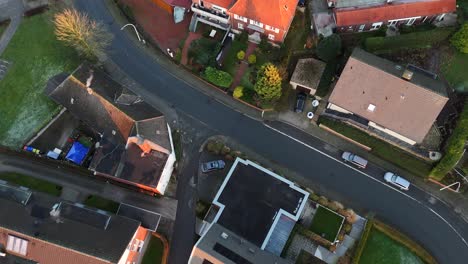 townhouses and homes with solar panels on roof during golden sunset. aerial top down flyover. american neighborhood in rural suburb.