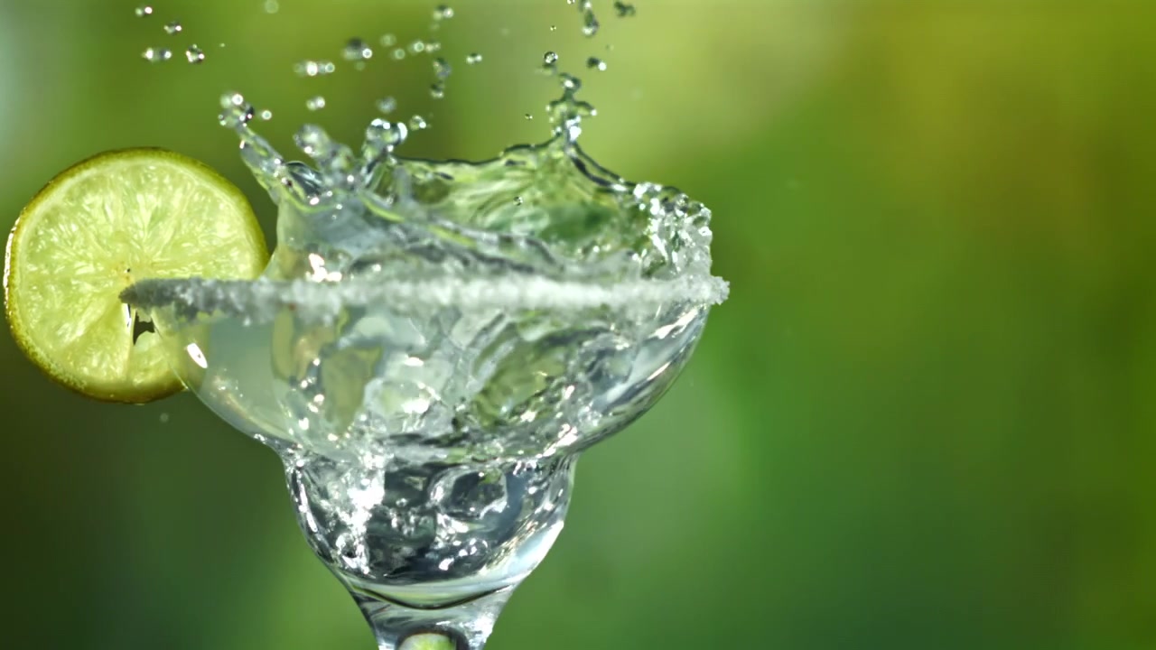Slow Motion Ice Cube Splashing into a Margarita Cocktail